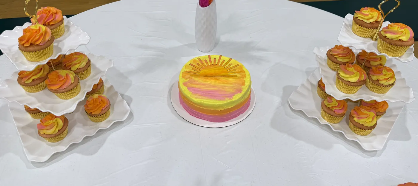 Sunburst buttercream cake with matching swirled cupcakes on tiered stands